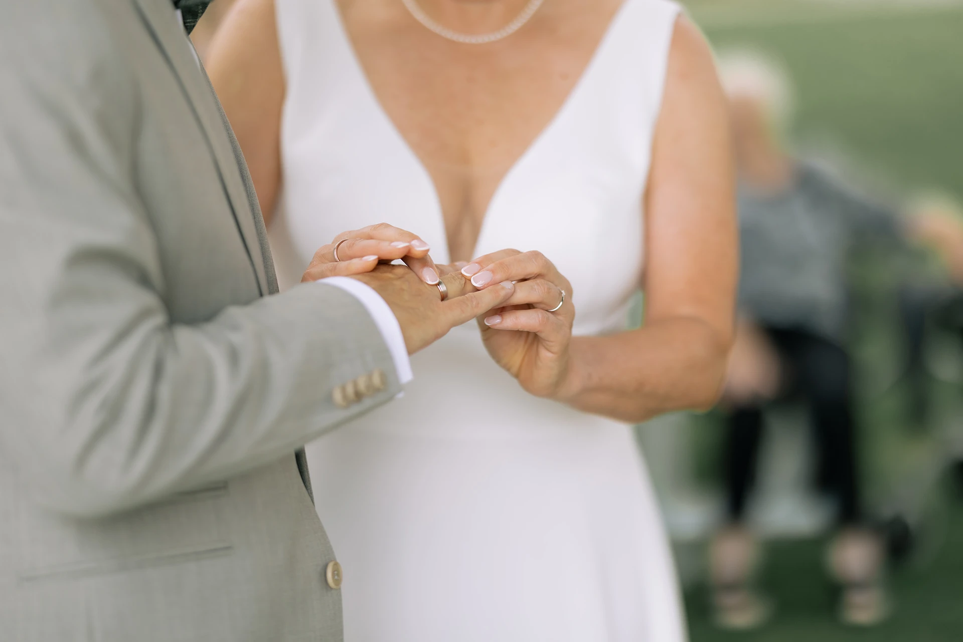 Die Braut steckt dem Bräutigam den Ring an den Finger.